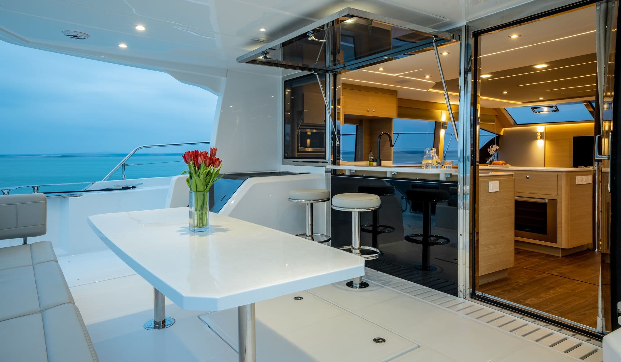 Aft cockpit of the Aquila 54 Yacht with a dining table and the salon doors open