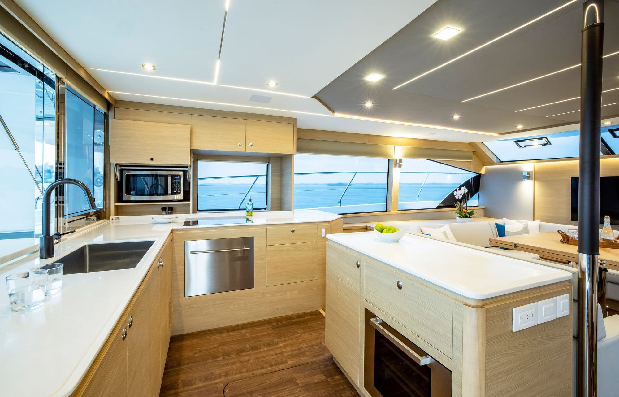 Galley aboard the Aquila 54 Yacht with wood cabinetry and white counters