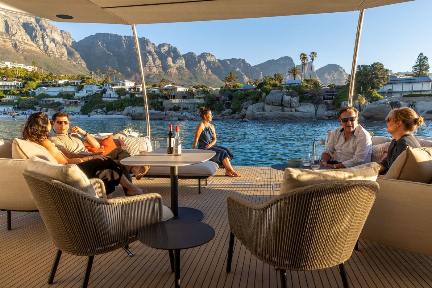 Guests relaxing in the aft cockpit lounge of the Leopard 53 Powercat at anchor