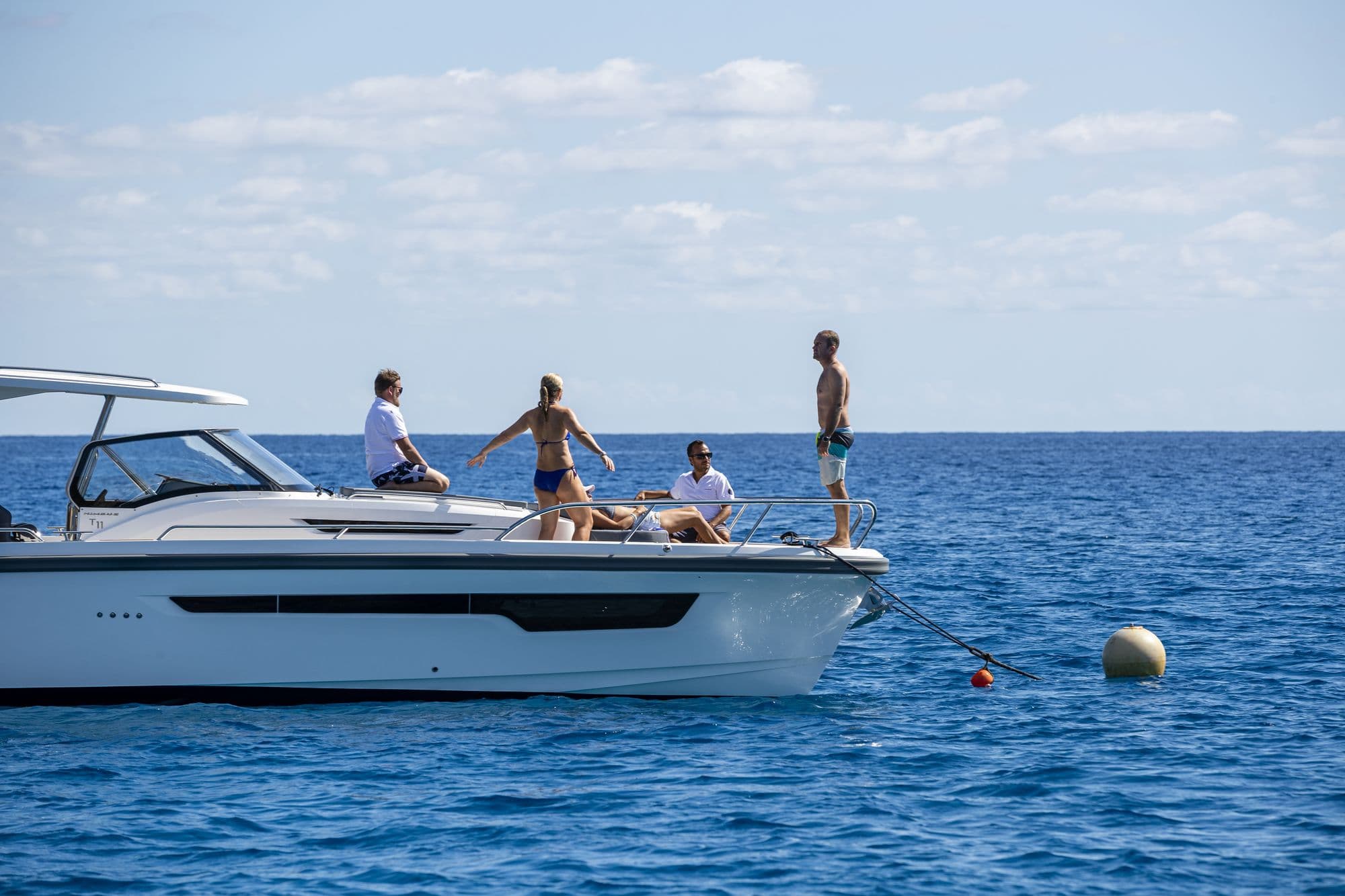 Guests on the foredeck of the Nimbus T11 at a mooring