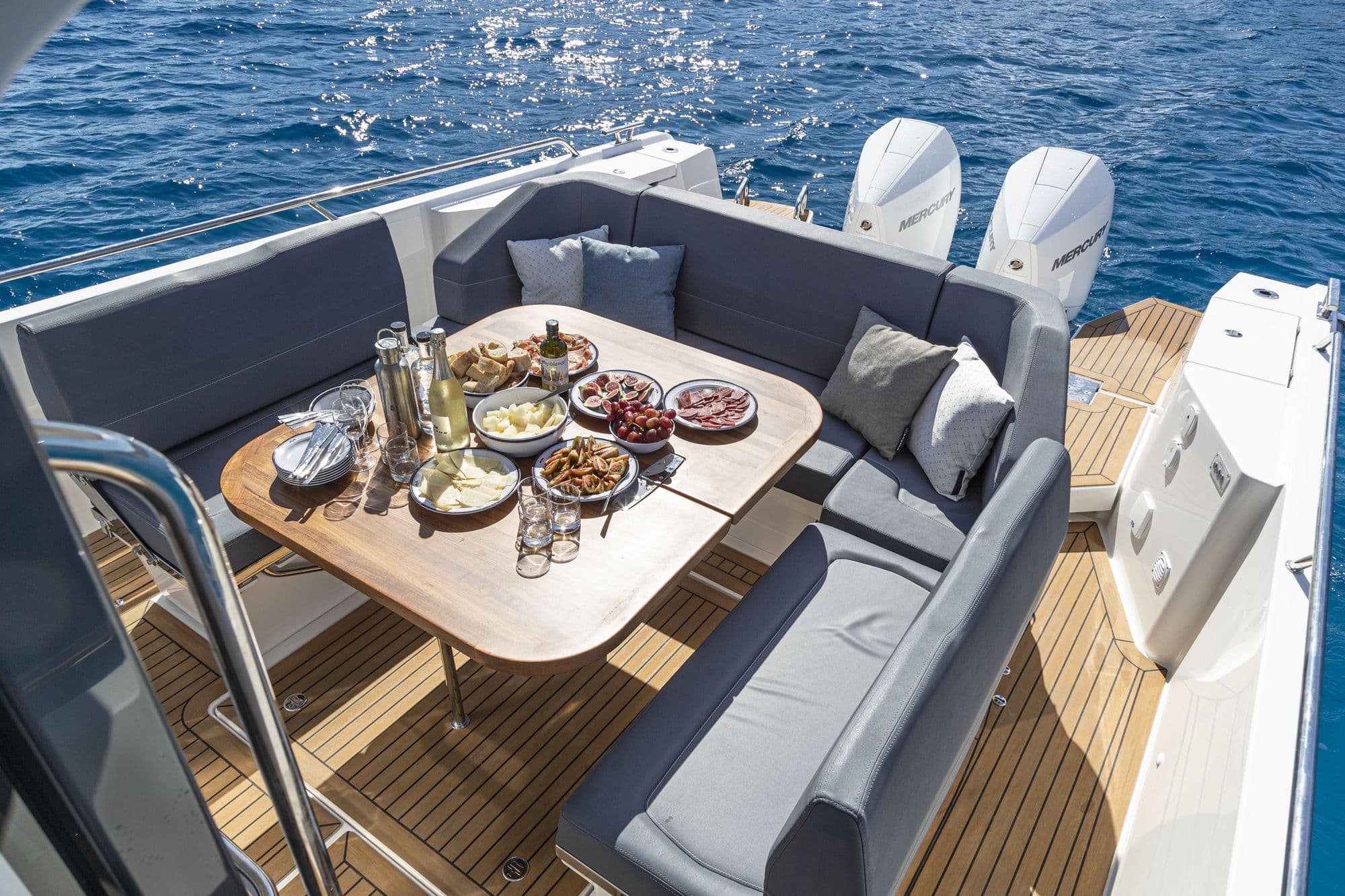 Aft lounge of the Nimbus T11 with sofas around a table set for lunch
