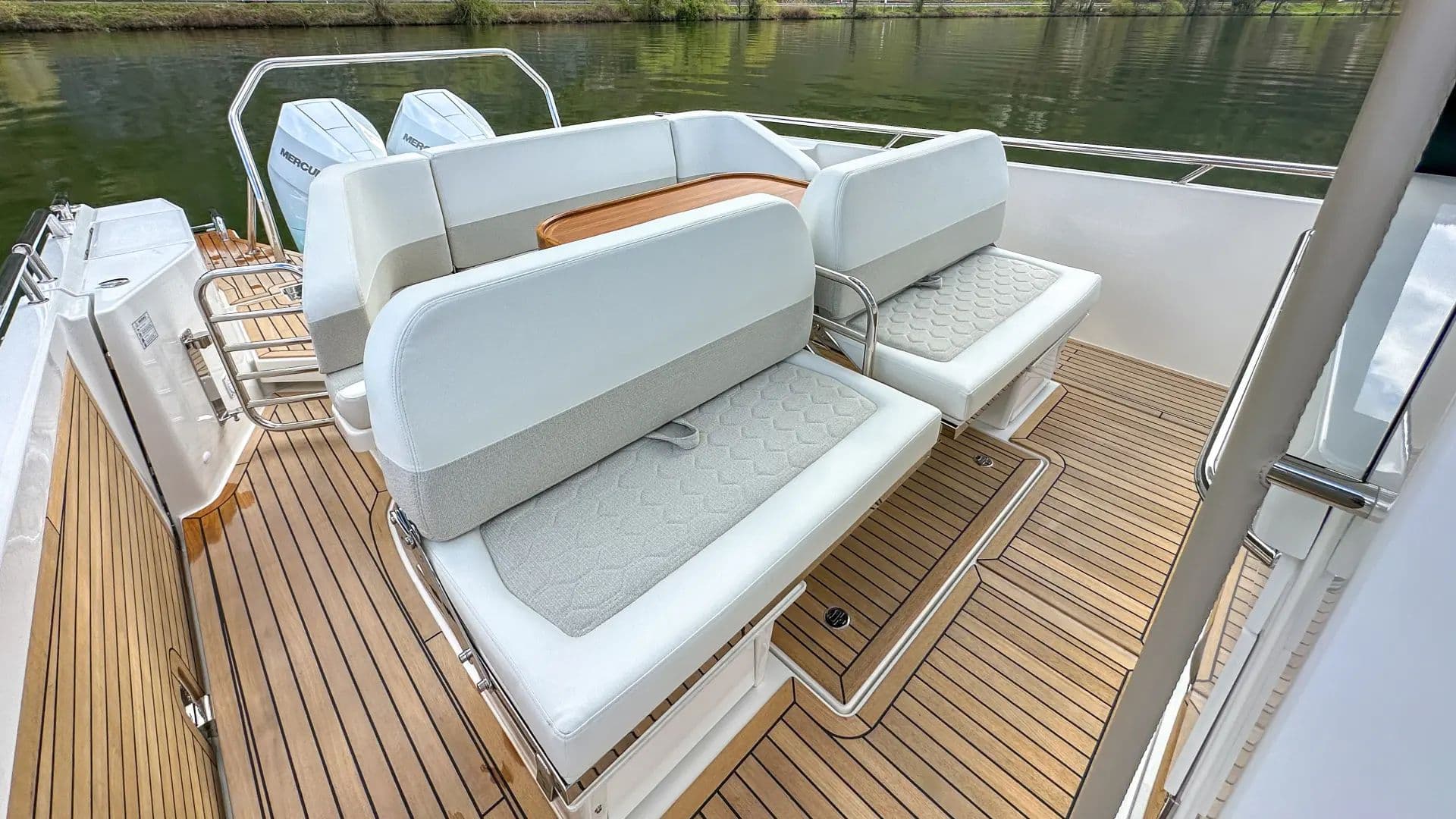 Aft lounge of the Nimbus T12 (Sport Tender 42) with sofas and a teak table