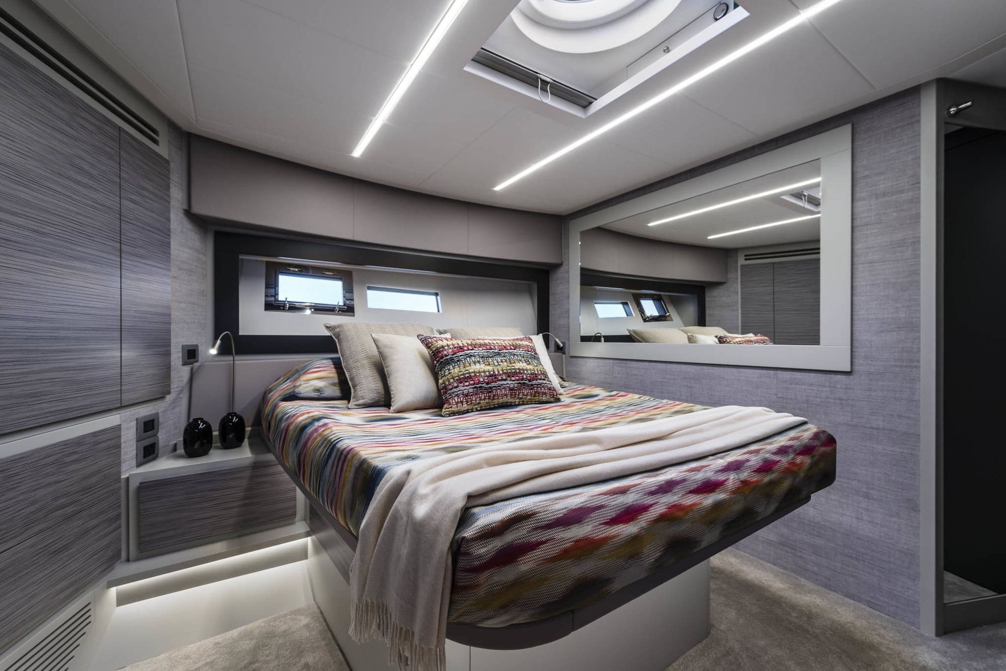 Guest cabin aboard the Pershing 6X with a double bed and skylight