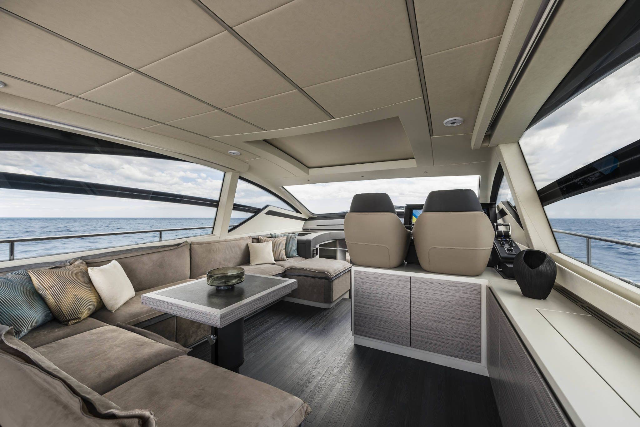 Pershing 6X main deck with the helm, sofas and dining area under the hardtop