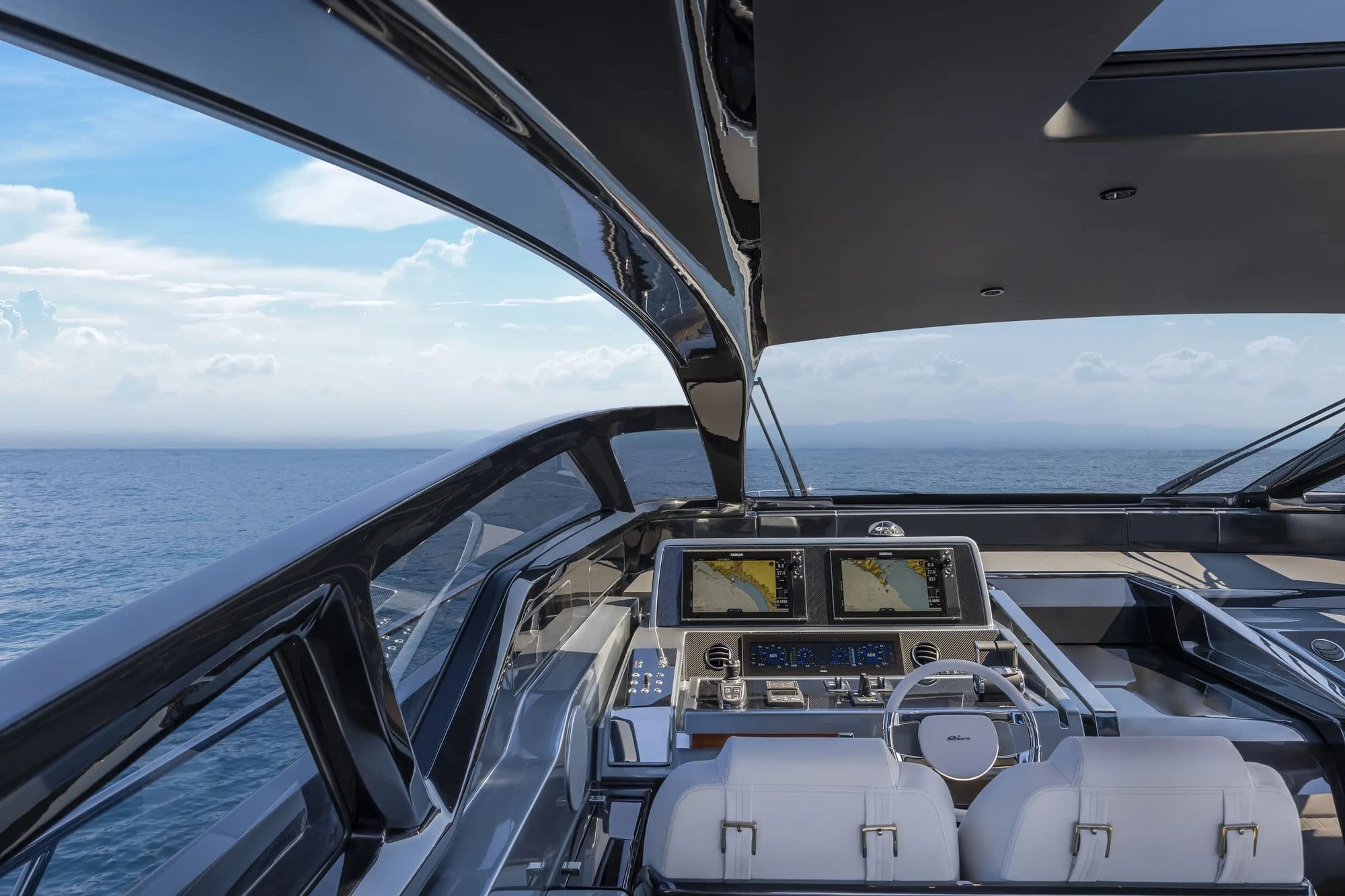 Helm station of the Riva 68' Diable with twin screens and white leather seats