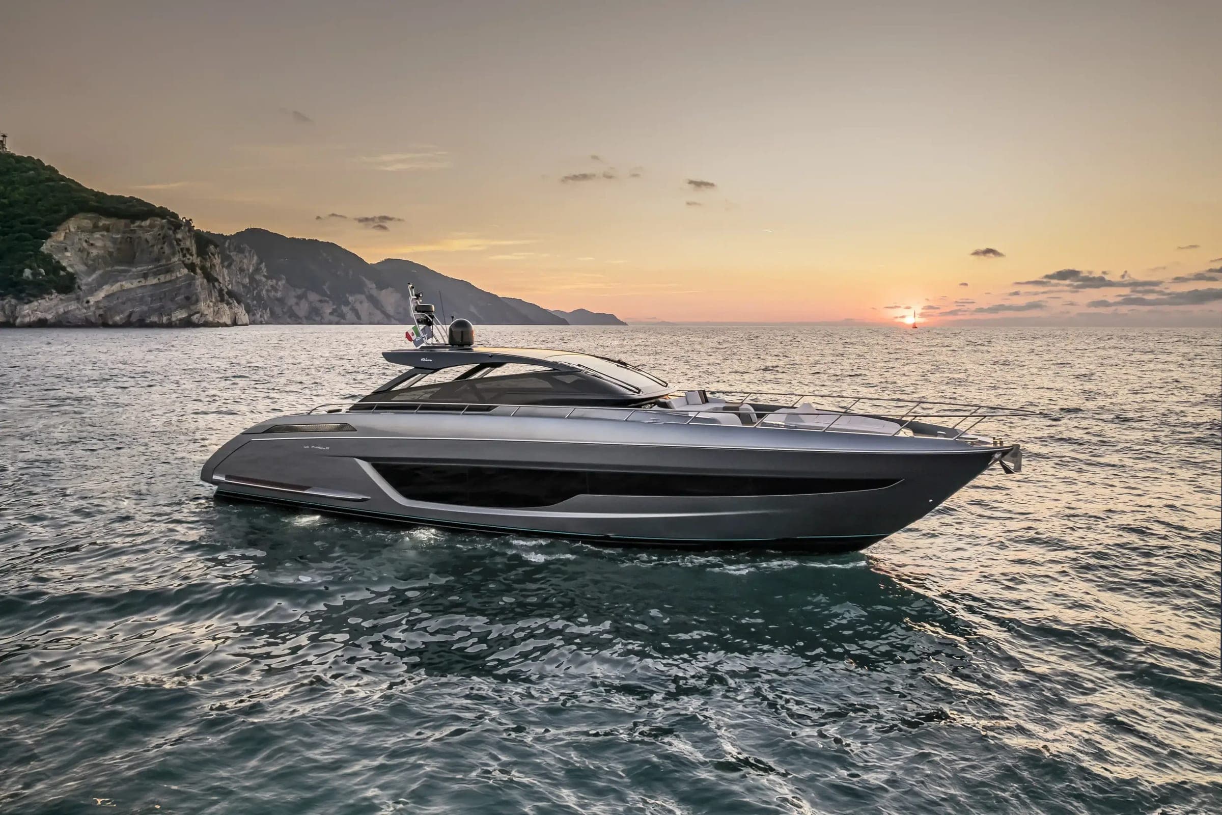 Riva 68' Diable sport yacht cruising along the coast at sunset
