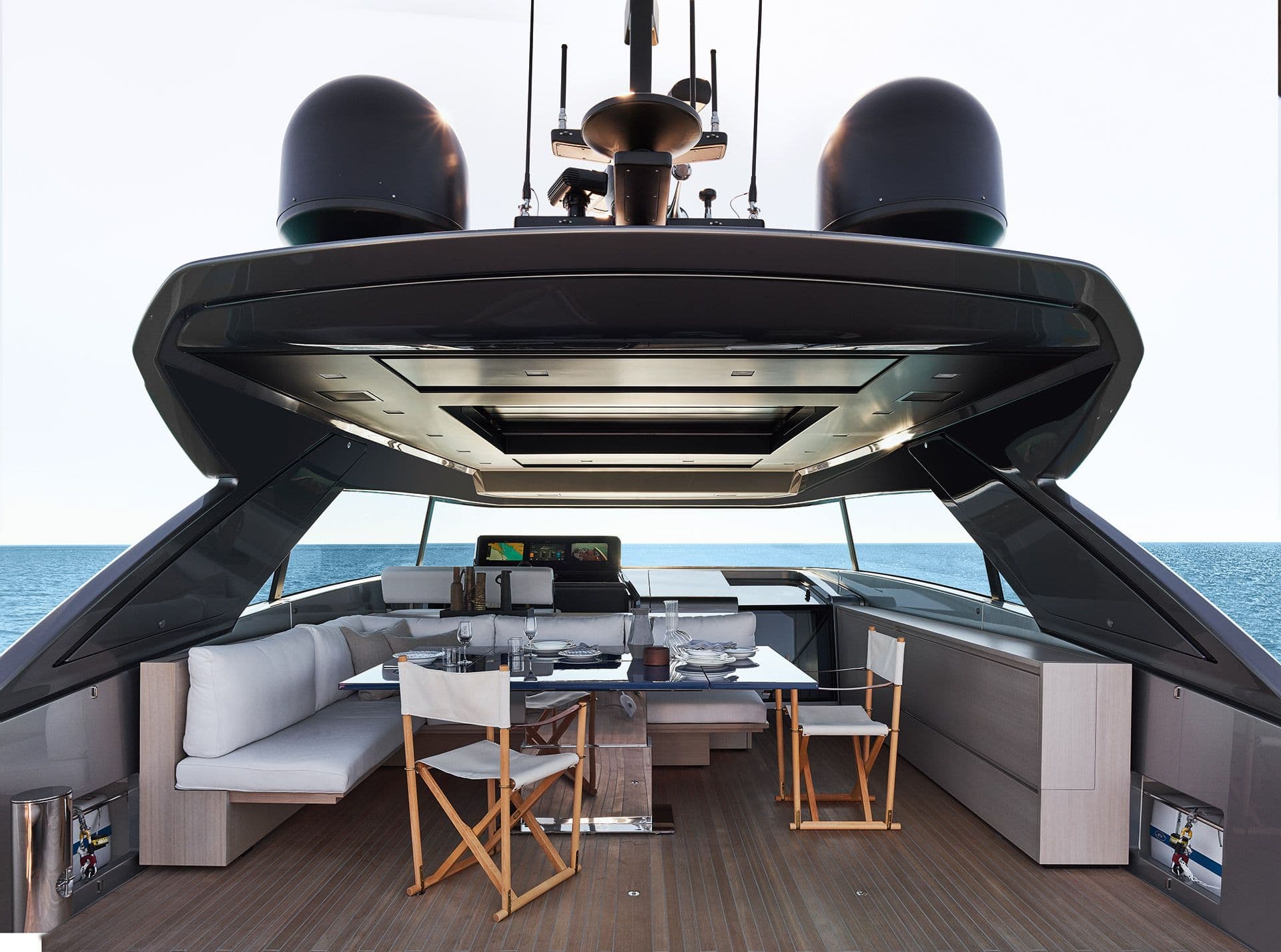 Flybridge of the Sanlorenzo SX76 with lounge seating, table and helm