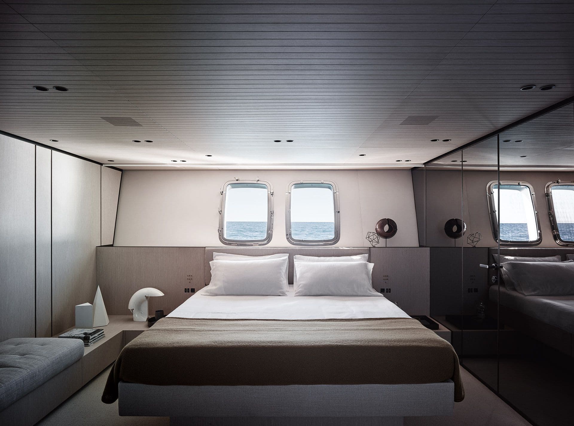 Owner's cabin aboard the Sanlorenzo SX76 with a double bed and hull windows
