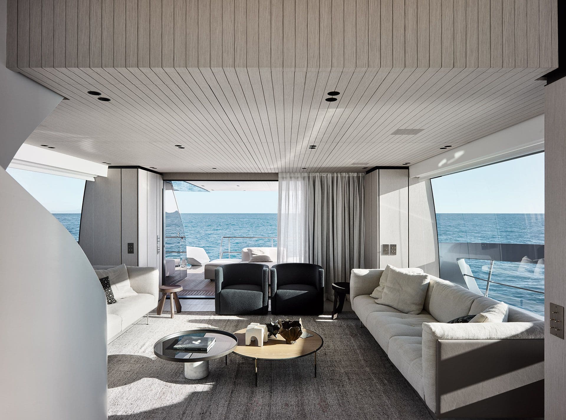 Saloon of the Sanlorenzo SX76 with tall windows and loose furniture