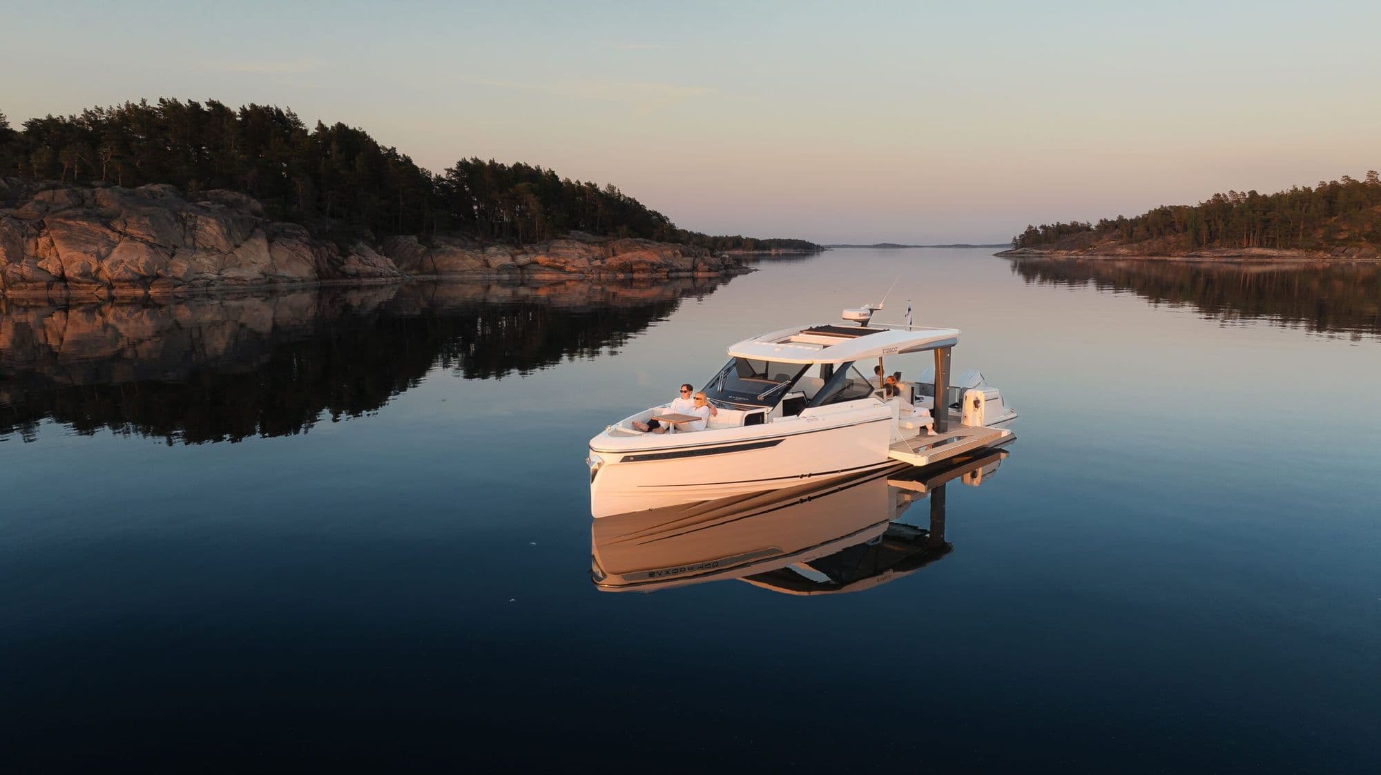 Saxdor 400 GTO at anchor at dusk in a calm, rocky bay