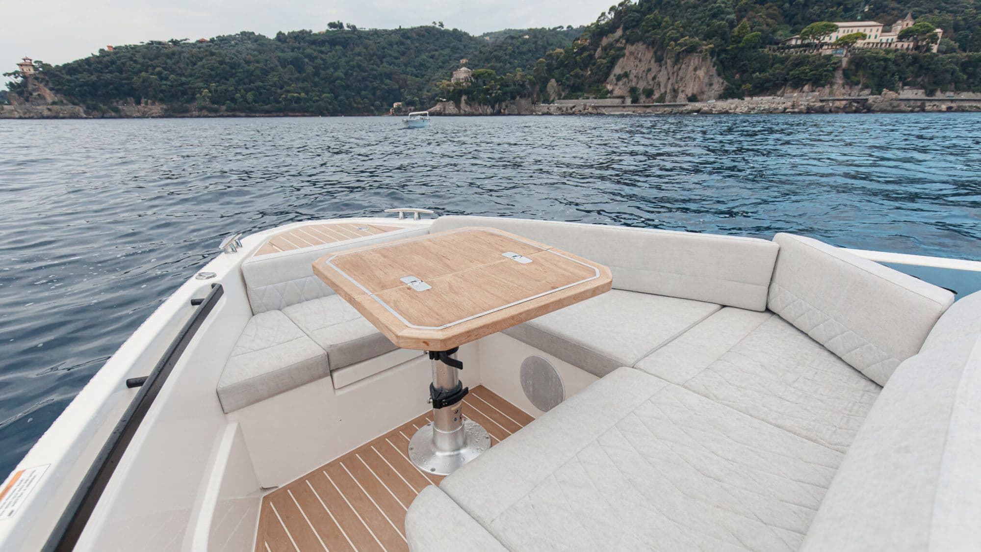 Bow lounge of the Saxdor 400 GTO with a wraparound sofa and a teak table
