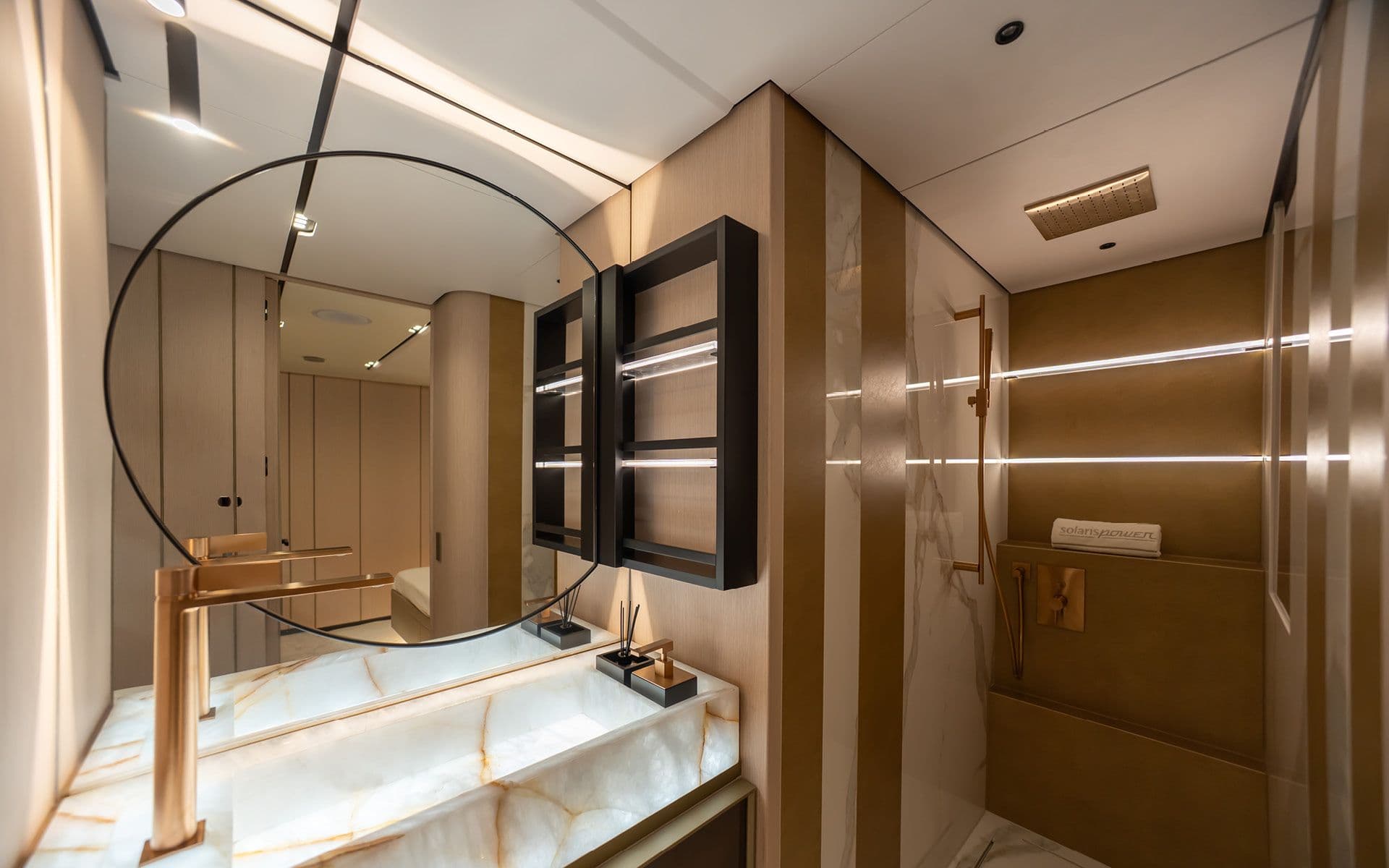 Bathroom aboard the Solaris Power 70 Long Range with a round mirror and wood finishes