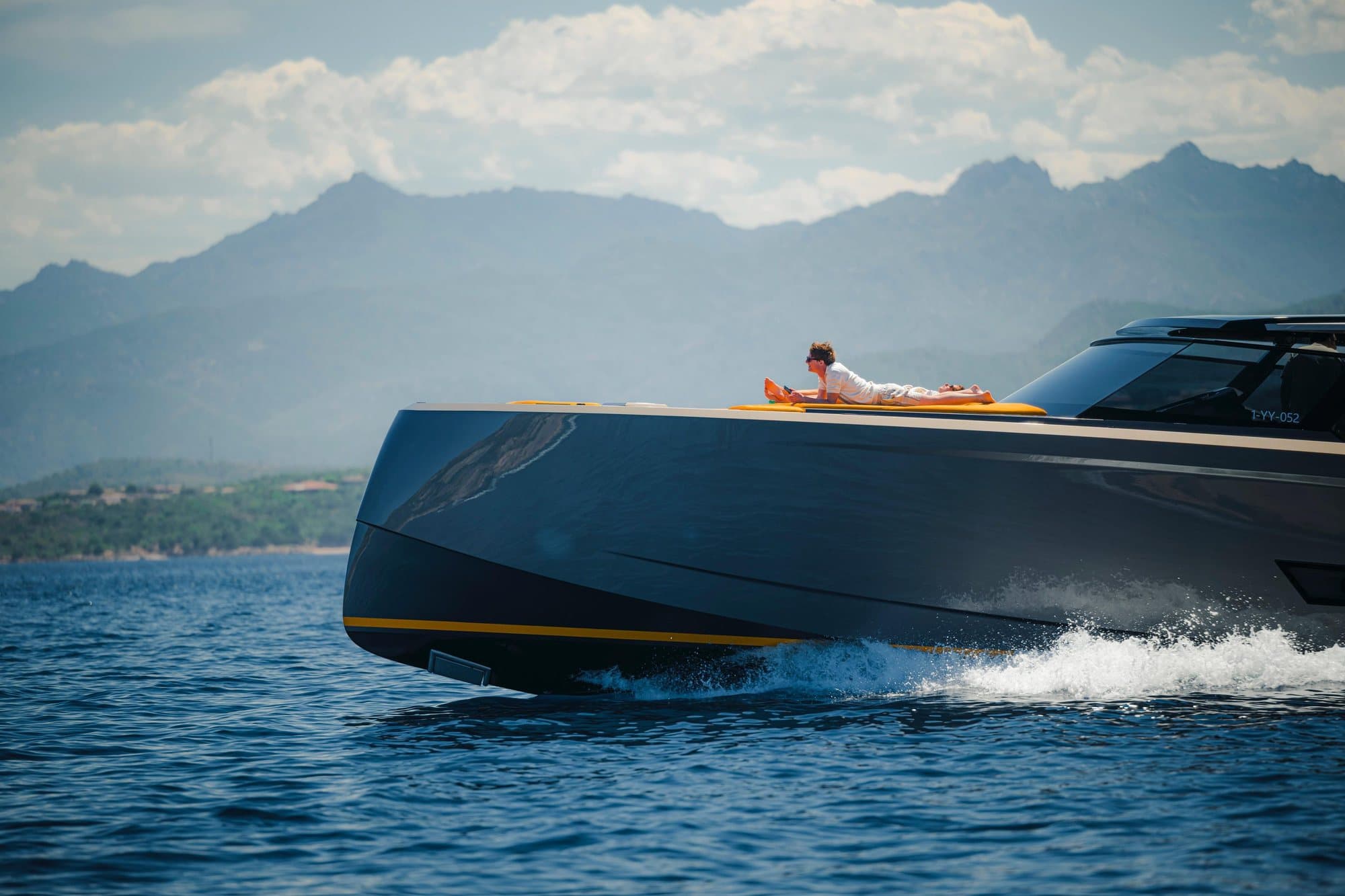 Vanquish VQ58 at speed with a guest sunbathing on the bow