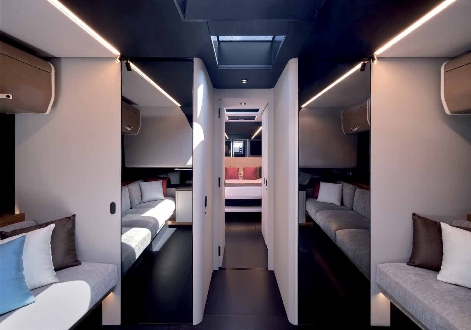 Lower deck of the wallypower58 with sofas either side of a corridor leading to the bow cabin