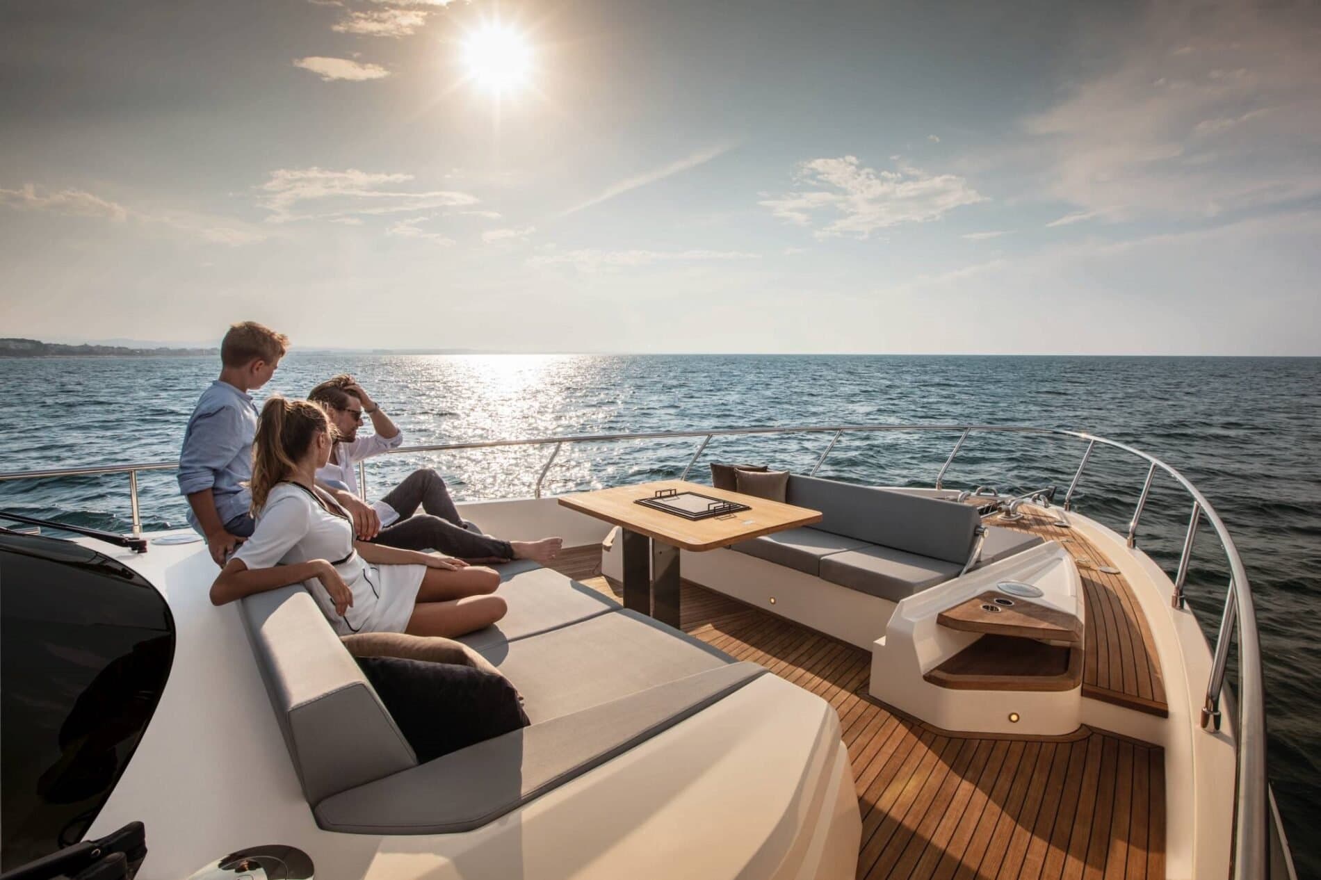 Family relaxing on a yacht's bow lounge at golden hour