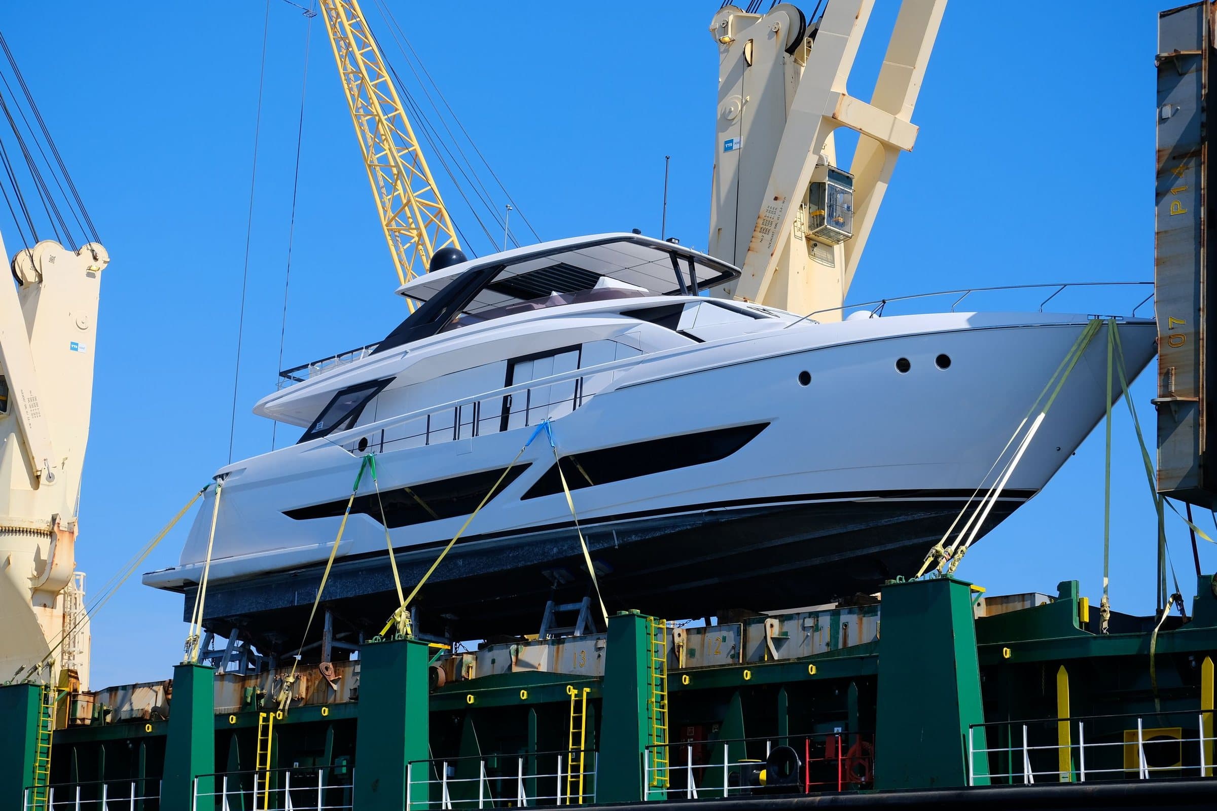 Modern motor yacht lifted out of the water in a boatyard
