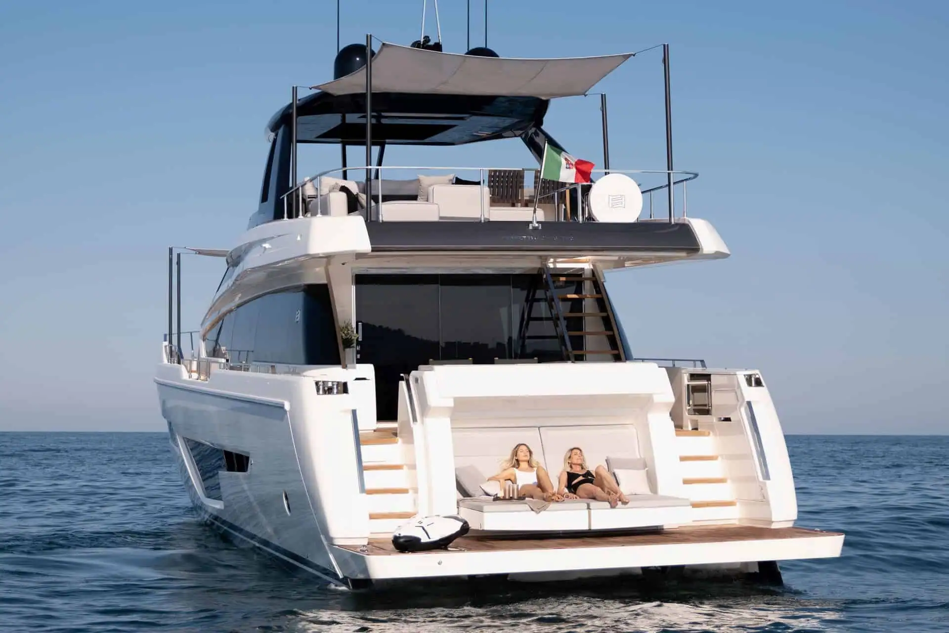 Guests relaxing on the swim platform of a Ferretti motor yacht on charter