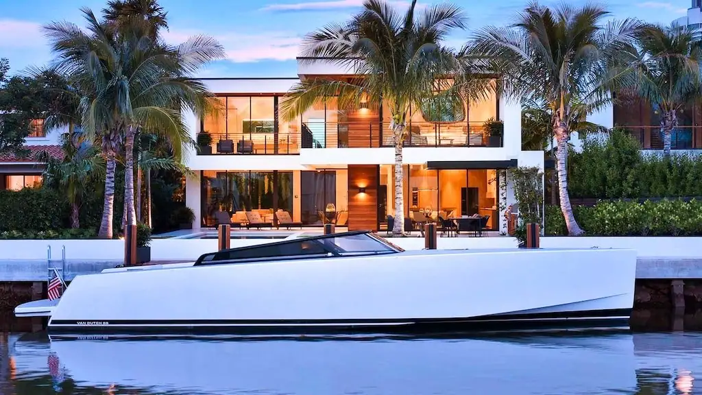Van Dutch 55 docked at a modern waterfront home at dusk